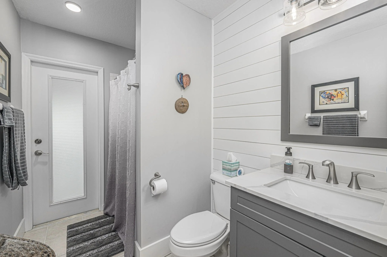 Professional real estate photo of a white kitchen with stainless appliances